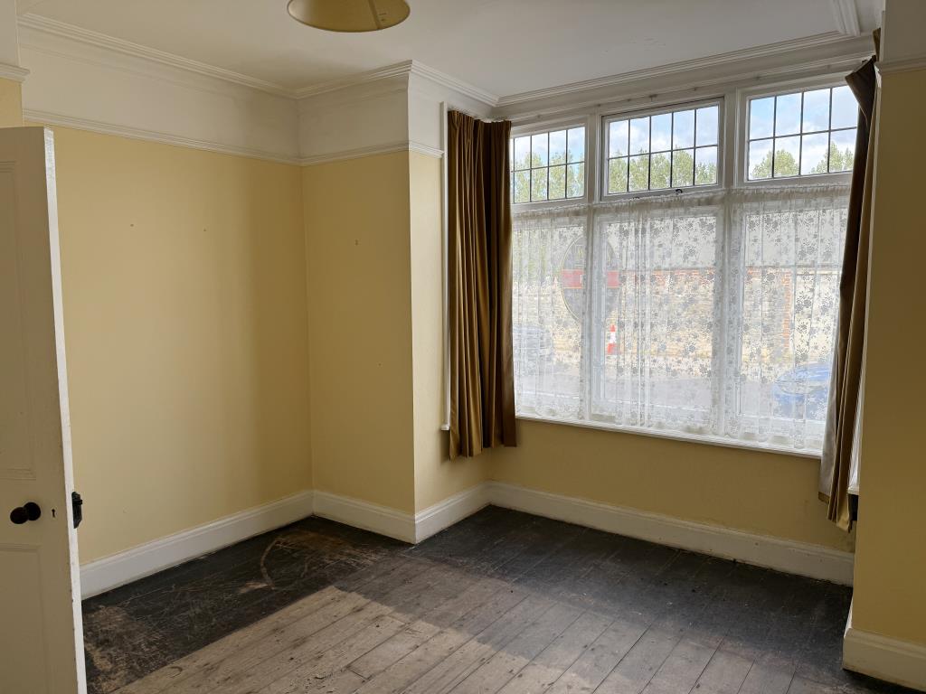 Lot: 106 - THREE-BEDROOM HOUSE IN NEED OF IMPROVEMENT - Living room with painted walls and bare flooring